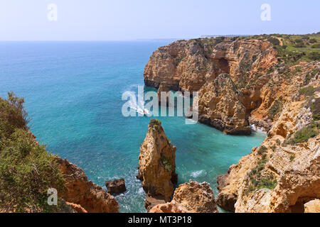 I luoghi di interesse turistico di scogliere di arenaria e le grotte in barca è un passatempo molto diffuso attività in Lagos, Portogallo. Costa Algarve in una mattina di sole in sp Foto Stock