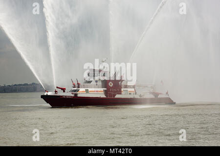 Il Fire Fighter II, un fireboat nella città di New York, spruzza acqua nel porto di New York. Foto Stock