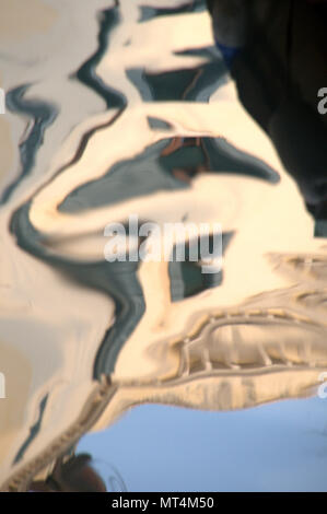 Riflessioni del muro veneziano in increspa acqua del canale Foto Stock