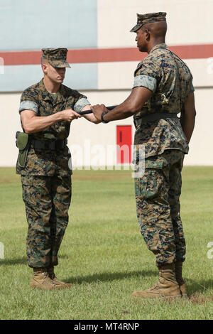 Stati Uniti Marine Corps Sgt. Il Mag. David M. Bianco, sinistra, Sergente Maggiore, 2° Battaglione di manutenzione (Maint. Bn.), combattere la logistica reggimento 25 (CLR), 2° Marine Logistics Group (MLG), passa il Non-Commissioned ufficiali spada di Lt. Col. Erik J. Smith, Comandante, 2° Maint. Bn., CLR-25, 2° MLG, durante un post e cerimonia di sfiato sul Camp Lejeune, N.C., 28 luglio 2017. Durante la cerimonia, Sgt. Il Mag. David M. Bianco comando rinunciato a Sgt. Il Mag. Daniel J. Warren. (U.S. Marine Corps photo by Lance Cpl. Tyler W. Stewart) Foto Stock