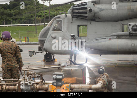 Gli ICM FUTENMA, Okinawa, in Giappone- Staff Sgt. Jahbari H. codici, centro, refuels un CH-53E Super Stallion elicottero Giugno 16 su Marine Corps Air Station Futenma Okinawa, in Giappone. CH-53E è il più grande e più pesante in elicottero militare degli Stati Uniti. Marines usa questi elicotteri per fornire truppe, i veicoli e le forniture provenienti da navi a riva. Codici è un'attività aeronautica chief con Marine elicottero pesante Squadron 462, terzo aeromobile Marina Wing, attualmente assegnato al primo velivolo Marina Wing sotto l'unità programma di installazione. Foto Stock