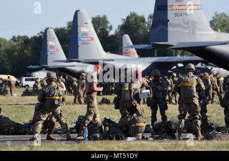 Il personale militare di più nazioni si radunò vicino a un aereo C-130 Hercules presso la base aerea Papa, in Ungheria, il 21 luglio 2017, in preparazione delle operazioni aviotrasportate durante l'esercitazione Swift Response 17. La documentazione fotografica d'archivio documenta l'interoperabilità multinazionale e le procedure di assemblaggio pre-volo collegate alle esercitazioni Saber Guardian 17 in tutta Europa. Foto Stock