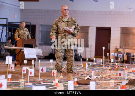 Fayetteville, North Carolina - Esercito Il Mag. Neil Edger, un ufficiale dell'intelligence militare con sede e Sede Società, trentesimo Armored Brigade Combat Team, punti in corrispondenza di posizioni sul modello del terreno a North Carolina National Guard Armory di Fayetteville, N.C. il 27 luglio 2017, durante una prova per il briefing daranno il loro comando il giorno seguente. Il modello del terreno e le prove sono parte della 30esima Warfighter dell esercizio in corso lì vicino a Fort Bragg che avrà il compito di preparare l'unità per grandi eventi di formazione in futuro. (U.S. Foto dell'esercito da Staff Sgt. Maria Junell Foto Stock