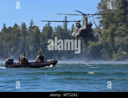 Berretti Verdi assegnato al primo delle forze speciali Gruppo (Airborne) salire una scaletta di corda sospesa da un CH-47 Chinook al lago americano, Base comune Lewis-Mccorda, Washington il 25 luglio 2017. La barca di sicurezza fornisce assistenza in caso di emergenza e recupera il personale. (U.S. Esercito Foto di Sgt. Codie Mendenhall/rilasciato) Foto Stock