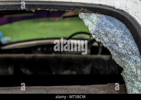 Una vecchia auto d'epoca in una cattiva condizione con finestrino posteriore rotto vetro incrinato shattered Foto Stock