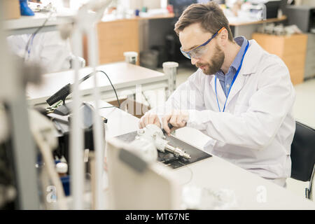 Lavoratore esperto tenendo il dispositivo di misurazione al di là Foto Stock
