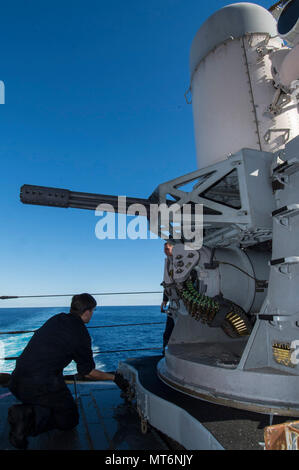 170726-N-DL434-256 CORAL SEA (26 luglio 2017) Fire Controlman 2a classe di Michael Jordan, da Virginia Beach, Virginia, ruota un Close-In sistema di armi (CIWS) in preparazione per un caricamento di munizioni a bordo dell'assalto anfibio nave USS Bonhomme Richard (LHD 6). Bonhomme Richard, ammiraglia del Bonhomme Richard Expeditionary Strike Group (ESG), è operativo in Indo-Asia-regione del Pacifico per rafforzare le partnership e di essere una pronta risposta in vigore per qualsiasi tipo di emergenza. (U.S. Foto di Marina di Massa Specialista comunicazione marinaio apprendista Gavin scudi/rilasciato) Foto Stock