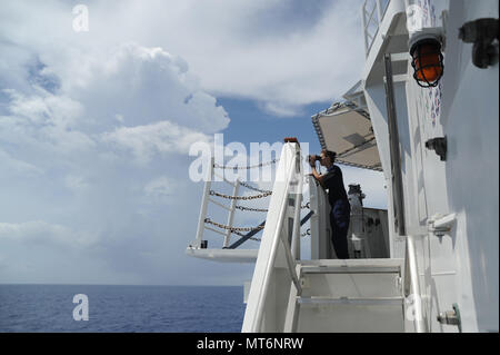 Coast Guard Petty Officer di terza classe di pagina di Elizabeth mans il belvedere sulla Guardacoste Tampa, mentre in corso nel Mar dei Caraibi, 24 luglio 2017. La Tampa, un 270-piede di medie endurance taglierina, è in grado di fornire una vasta gamma di missioni, per includere la ricerca e il salvataggio e il contatore di pattuglie di farmaco. Coast Guard foto di Sottufficiali di 2a classe di Lisa Ferdinando Foto Stock