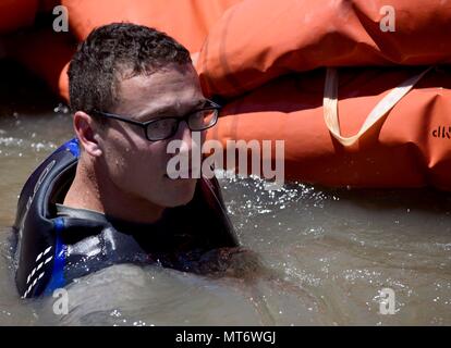 Tech. Sgt. Garrett Wright, XXII Operations Support Squadron evasione di sopravvivenza di resistenza e di fuga e di personale specializzato di recupero, tira una zattera di salvataggio a riva dopo la conduzione di acqua survival training di aggiornamento luglio 12, 2017 a Santa Fe il lago, Augusta, Kan. Wright conduce vari tipi di sere formazione per gli avieri a McConnell Air Force Base. (U.S. Air Force foto/Airman 1. Classe Erin McClellan) Foto Stock