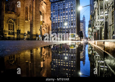 Gli edifici e le luci riflesse in una pozza d'acqua nelle strade di Manhattan. Manhattan, New York, Stati Uniti. Il 1 maggio 2018. Foto Stock
