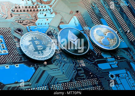 Bitcoin, Ethereum, monete di ondulazione sulla scheda madre del computer, cryptocurrency Concetto di investimento Foto Stock