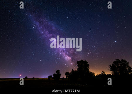 Una lunga esposizione fotografia della Via Lattea e il suo centro galattico su un campo vicino alla città di Madrid in Spagna. Foto Stock
