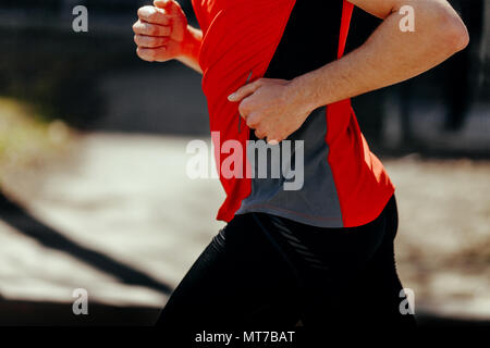 Le mani e il corpo di runner Uomo in camicia rossa e pantaloncini neri Foto Stock