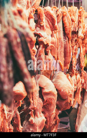 Macellaio di carne di maiale di vendita nel mercato di Hong Kong. Foto Stock