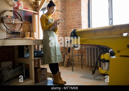 Femmina giovane artigiano in officina Foto Stock