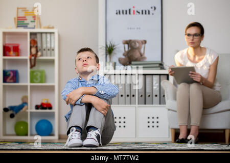 Psicologo giovane parlando con il ragazzo depresso nel suo ufficio Foto Stock