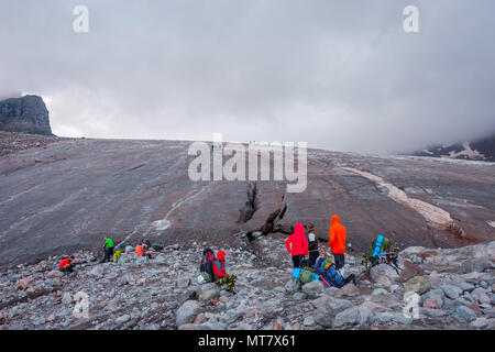 Gruppo di irriconoscibile la gente camminare sul ghiacciaio Kazbegi, Georgia Foto Stock