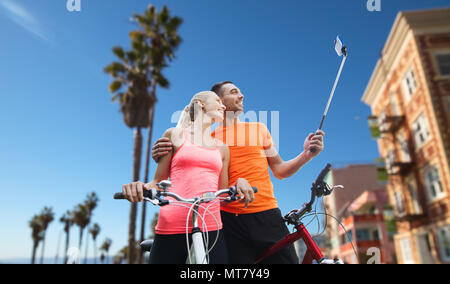 Giovane con la bicicletta e lo smartphone selfie stick Foto Stock