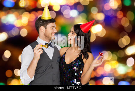 Coppia felice con party soffianti divertendosi Foto Stock