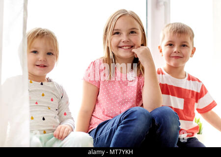 Felici i bambini divertendosi in corrispondenza della finestra Foto Stock