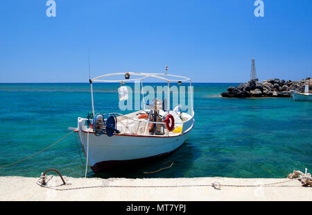 Piccola vecchia barca bianca da pesca nel porto, legata al ormeggio. Vista frontale. Bel mare e cielo blu e tranquillo. Creta, Grecia. Foto Stock