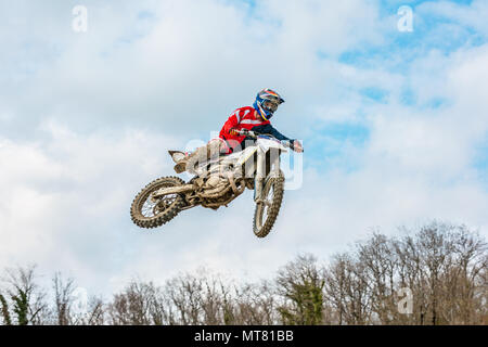 Racer su un motociclo in volo, salti e prende il largo su un trampolino di lancio verso il cielo. Foto Stock