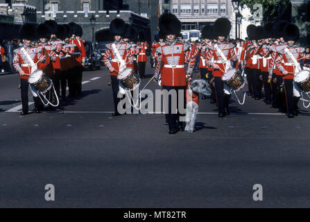 1988 storico piede irlandese guardie militari di MARCHING BRASS BAND con il cane mascotte cambiando la guardia il Mall London Inghilterra England Regno Unito Foto Stock