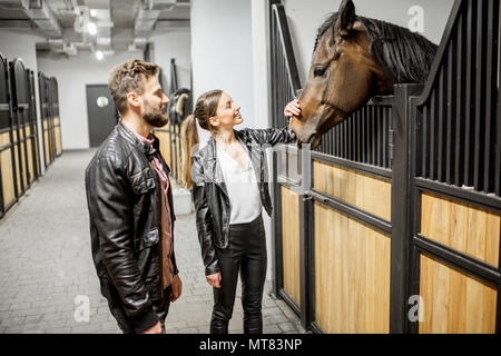 Coppia con il cavallo in stabile Foto Stock