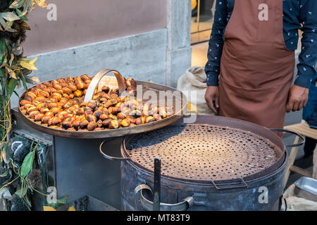 L'uomo vendere tostatura di castagne e marroni a strade di Roma, Italia Foto Stock