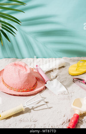 Spiaggia di sabbia con asciugamano, cappello e accessori estivi con copia spazio. Vacanze e viaggi elementi. Vacanza tropicale sfondo. Foto Stock