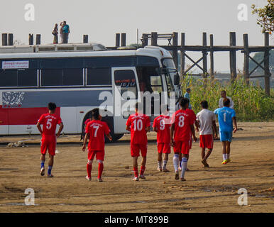 Mandalay, Myanmar - Feb 22, 2016. Una squadra di calcio a piedi sulla strada rurale a sunrise di Mandalay, Myanmar. Foto Stock