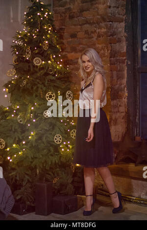 Elegante donna felice decorazione albero di natale.stagionale concetto dei messaggi di saluto Foto Stock