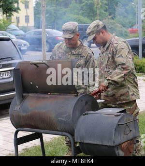 Brig. Gen. Antonio Aguto, comandante del settimo Esercito di formazione comando, dà consigli di grigliatura a Sgt. Issac Gonzalez, operazioni sottufficiale assegnato a 7ATC presso la sede centrale e sede aziendale, in Graffenwoehr, Germania, 11 maggio 2018. Soldati dal 7ATC ha condotto un grafico a torta-in--faccia caso a raccogliere fondi per l'esercito di soccorso in caso di emergenza la campagna. Finora la manifestazione ha raisied oltre 400 dollari in un'ora. (U.S. Esercito foto di Sgt. Marlon Stili) Foto Stock