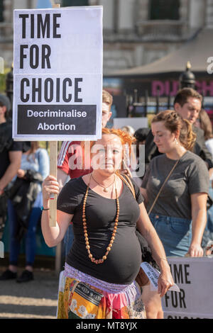 Belfast, Irlanda del Nord. 28/05/2018 - una donna incinta detiene una targhetta dicendo "Tempo per la scelta. Depenalizzare l'aborto". Circa 500 persone si radunano a Belfast City Hall di chiamare per la depenalizzazione dell aborto in Irlanda del Nord. Si tratta del giorno dopo un referendum svoltosi nella Repubblica di Irlanda ha restituito un sostanziale sì alla rimozione del ottavo emendamento della costituzione che dà uguale diritto di vita sia per la madre che per il bambino, efficacemente il divieto di aborto in tutte le circostanze. Foto Stock