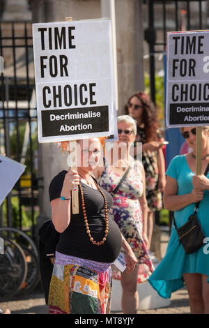 Belfast, Irlanda del Nord. 28/05/2018 - una donna incinta detiene una targhetta dicendo "Tempo per la scelta. Depenalizzare l'aborto". Circa 500 persone si radunano a Belfast City Hall di chiamare per la depenalizzazione dell aborto in Irlanda del Nord. Si tratta del giorno dopo un referendum svoltosi nella Repubblica di Irlanda ha restituito un sostanziale sì alla rimozione del ottavo emendamento della costituzione che dà uguale diritto di vita sia per la madre che per il bambino, efficacemente il divieto di aborto in tutte le circostanze. Foto Stock