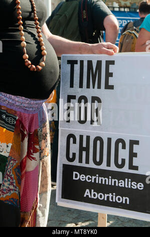 Belfast, Irlanda del Nord. 28/05/2018 - una donna incinta detiene una targhetta dicendo "Tempo per la scelta. Depenalizzare l'aborto". Circa 500 persone si radunano a Belfast City Hall di chiamare per la depenalizzazione dell aborto in Irlanda del Nord. Si tratta del giorno dopo un referendum svoltosi nella Repubblica di Irlanda ha restituito un sostanziale sì alla rimozione del ottavo emendamento della costituzione che dà uguale diritto di vita sia per la madre che per il bambino, efficacemente il divieto di aborto in tutte le circostanze. Foto Stock