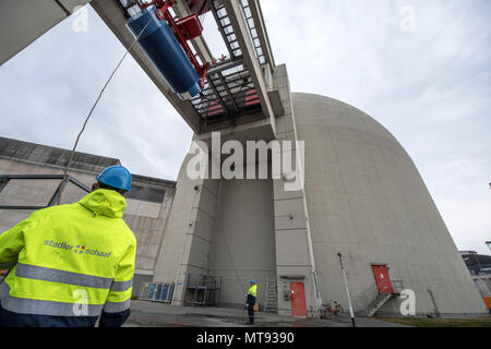 17 maggio 2018, Biblis, Germania: utilizzando un heavy-duty, gru di sollevamento dei lavoratori un blu container Castor all'interno di uno dei blocchi dei reattori di Biblis Centrale Nucleare. Lì, lo speciale contenitore viene riempito di acqua del serbatoio del reattore con gli elementi di combustibile, per essere poi portato in uno stoccaggio intermedio sui motivi della centrale nucleare. Dopo la fase di tedesco-del nucleare, l'impianto di alimentazione in Biblis saranno gradualmente smantellato. Foto: Boris Roessler/dpa Foto Stock