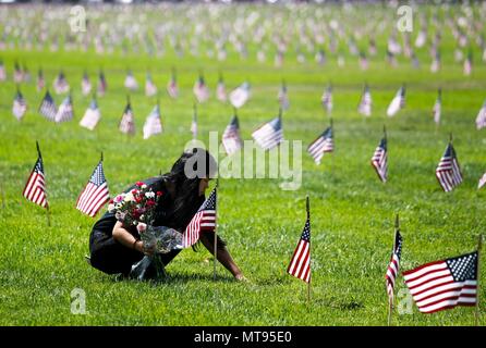 Los Angeles, Stati Uniti d'America. 28 Maggio, 2018. Una ragazza luoghi fiori su un veterano di pietra tombale durante il Memorial Day rispetto alla Los Angeles Cimitero Nazionale di Los Angeles, negli Stati Uniti il 28 maggio 2018. Credito: Zhao Hanrong/Xinhua/Alamy Live News Foto Stock