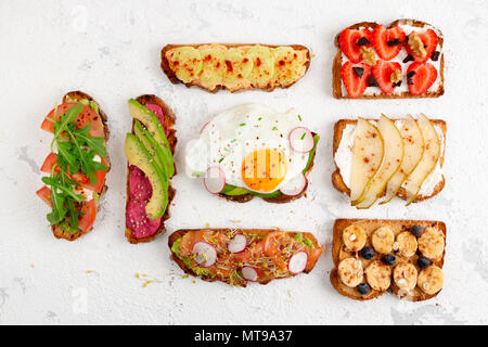 Assortimento di sana colazione toast su un bianco sfondo rustico. Vista superiore, laici piatta Foto Stock