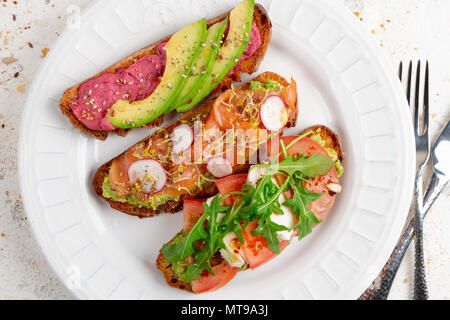 Assortimento di sana colazione toast su un piatto su un bianco sfondo rustico. Vista superiore Foto Stock