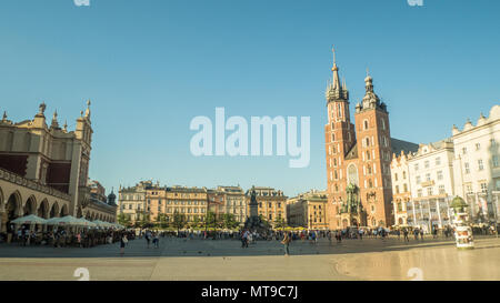 (Principale) medievale Piazza del Mercato della città vecchia di Cracovia in Polonia. Gotica in mattoni St Marys Chiesa diritto & il Rinascimento panno 'Hall' shopping mall a sinistra. Foto Stock