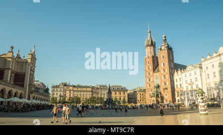 (Principale) medievale Piazza del Mercato della città vecchia di Cracovia in Polonia. Gotica in mattoni St Marys Chiesa diritto & il Rinascimento panno 'Hall' shopping mall a sinistra. Foto Stock