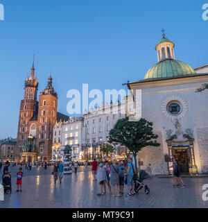 (Principale) medievale Piazza del Mercato nella città vecchia di Cracovia in Polonia, con il mattone Gothic St Marys chiesa a sinistra. Foto Stock