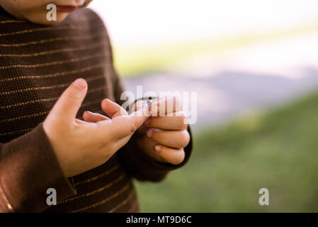 Un bambino ragazza con un bug nelle sue mani. Foto Stock