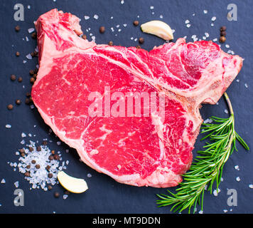 Materie t-bone steak su sfondo scuro. Foto Stock