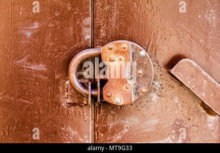 Lucchetto arrugginito su una vecchia porta di metallo Foto Stock