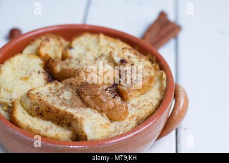 Pentola di coccio di il budino di pane e burro su bianco bordo tabella Foto Stock
