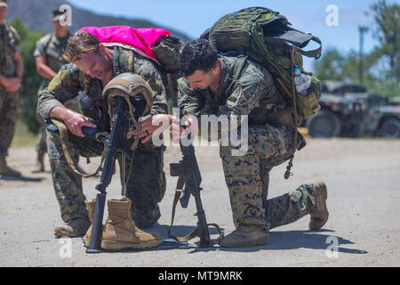 Marines luogo dog tag di un Marine caduti sul buttstock del fucile durante la decima edizione della sfida Recon in Marine Corps base Camp Pendleton, 17 maggio 2018. Le dog tag sono usurati intorno a ciascun partecipante il collo durante la totalità dell'evento, fino a quando non hanno raggiunto la fine e li ha collocati su di fucile. (U.S. Marine Corps photo by Lance Cpl. Kerstin Roberts/rilasciato) Foto Stock