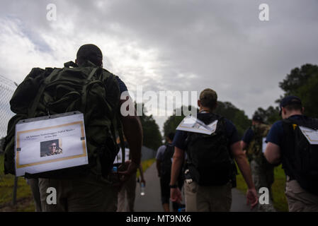 I membri dell'Ufficio di Investigazioni Speciali trasportare zaini dedicato durante un ruck marzo come parte della settimana di polizia, 18 maggio 2018, presso Seymour Johnson Air Force Base in North Carolina. Il team è stato marciando per diversi agenti speciali che sono stati uccisi nella linea del dazio, compreso il Mag. Adrianna Vorderbruggen, che era uno dei 6 soldati uccisi da un attentatore suicida in Afghanistan nel 2015. (U.S Air Force photo by Staff Sgt. Brittain Crolley) Foto Stock