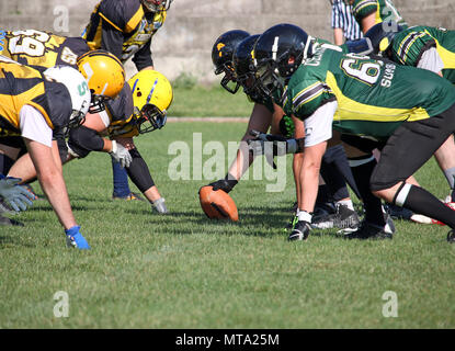 American football giocatori sulla linea di scrimmage sono pronti per iniziare il gioco Foto Stock